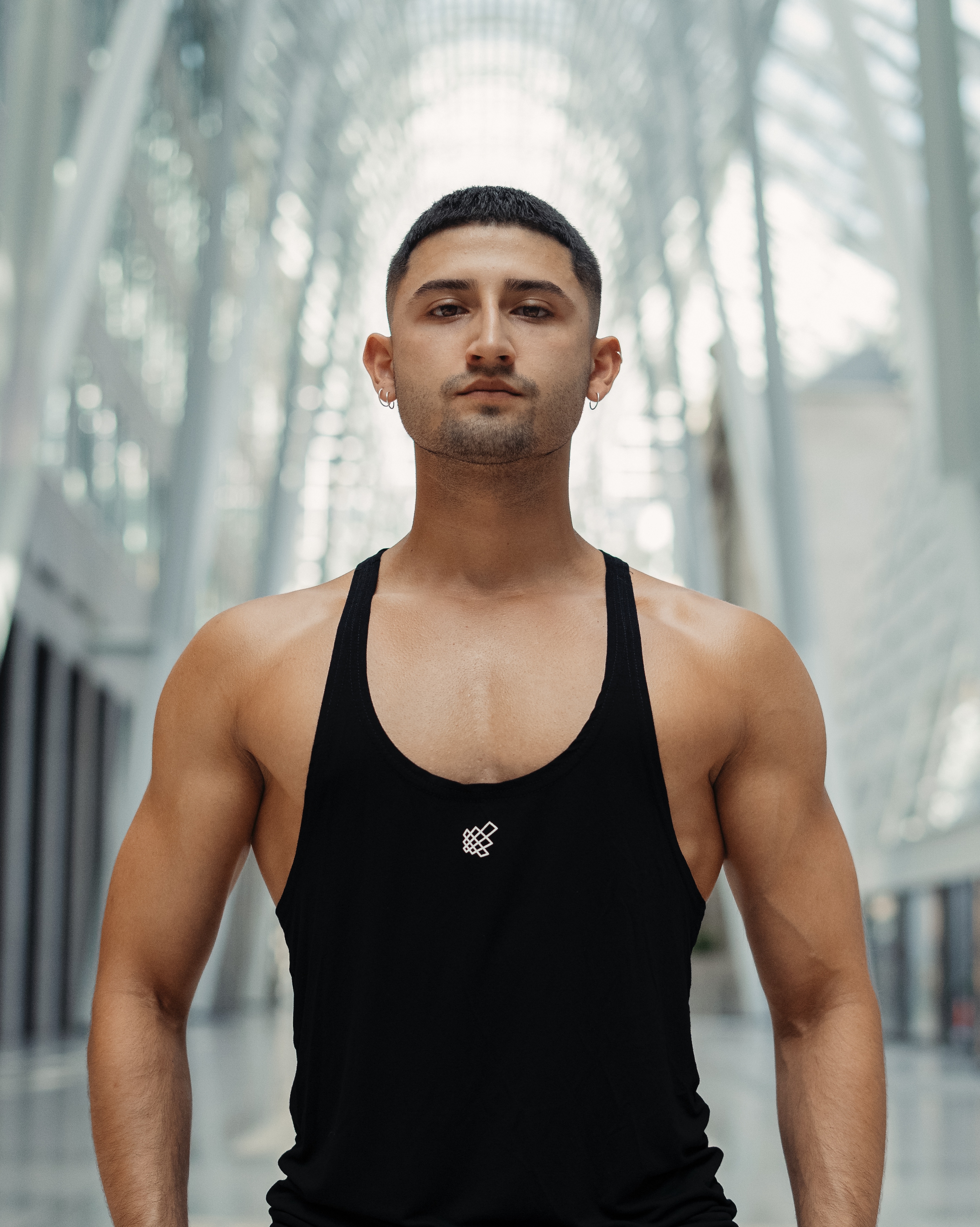 Picture of coach Armando wearing a black tank top showing upperbody muscles